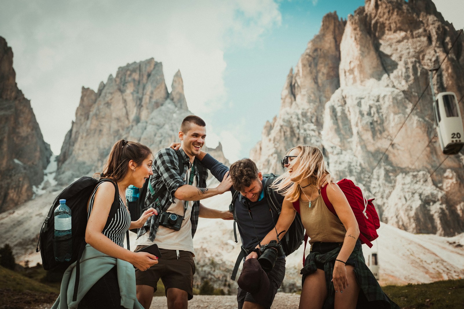 Small group of like-minded travellers sitting peacefully together on a scenic mountain ridge at sunset